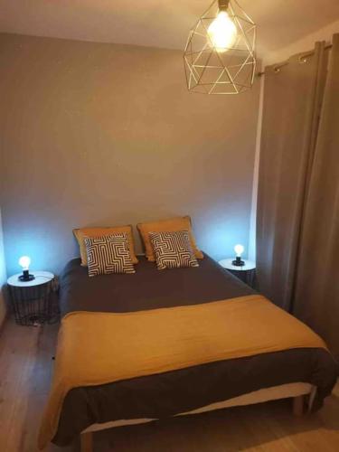 une chambre avec un lit avec deux oreillers dessus dans l'établissement Charmant appartement au calme, à Bourg-en-Bresse