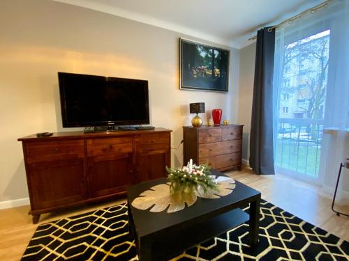 uma sala de estar com uma televisão de ecrã plano e uma mesa de centro em Apartament Golden Studio em Mielec