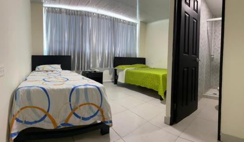 a bedroom with two beds and a window at Hotel Gloria Del Norte in Cartagena de Indias