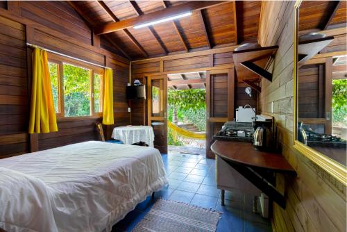 1 dormitorio con 1 cama en una habitación de madera en Estalagem Don Pablo, en Bombinhas