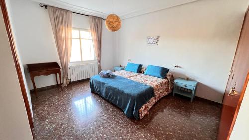 ein Schlafzimmer mit einem Bett mit blauen Kissen und einem Klavier in der Unterkunft Dulcevida in Riópar