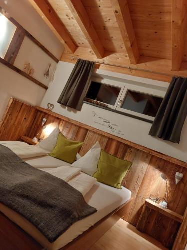 a bedroom with two beds in a room with wooden walls at Apart Lechtraum in Stanzach