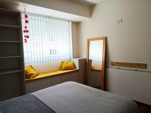 1 dormitorio con espejo, cama y ventana en Agustina en Mar del Plata