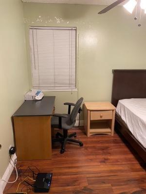 um quarto com uma secretária, uma cama, uma secretária e uma cadeira. em rooms available in single family house em Los Angeles