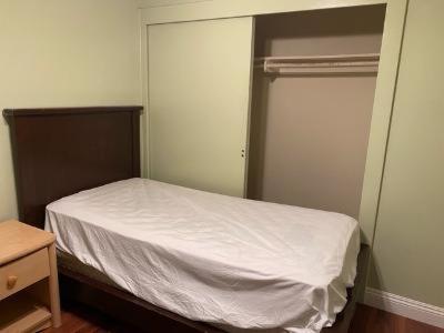 a small bedroom with a white bed and a closet at rooms available in single family house in Los Angeles