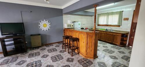 cocina con TV y barra con taburetes en Mi casita en Miramar