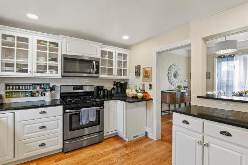 a kitchen with white cabinets and black counter tops at Garden City House with Hot Tub in Colorado Springs