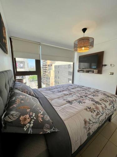 1 dormitorio con cama y ventana grande en Lindo y equipado depto de 1d/1b en Metro Manquehue, en Santiago