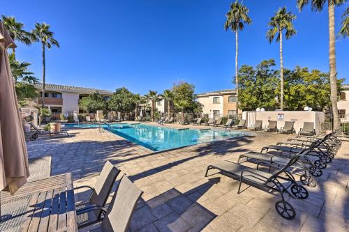 a swimming pool with lounge chairs and palm trees at Families and Dogs Welcome! Phoenix Condo with Pool in Phoenix