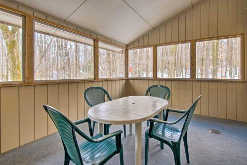 a table and chairs in a room with windows at Cozy Lake Ariel Home with Community Amenities! in Lake Ariel