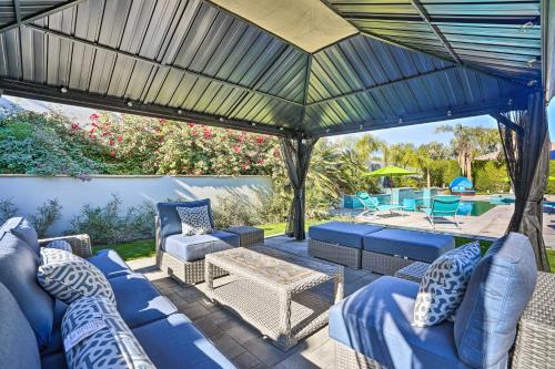 a patio with a blue couch and chairs under a pergola at Private Pool and Spa Spacious Home in Bermuda Dunes in Bermuda Dunes