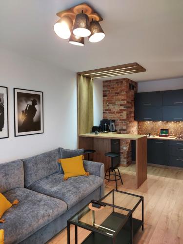 a living room with a couch and a kitchen at Patio Jazz in Koszalin