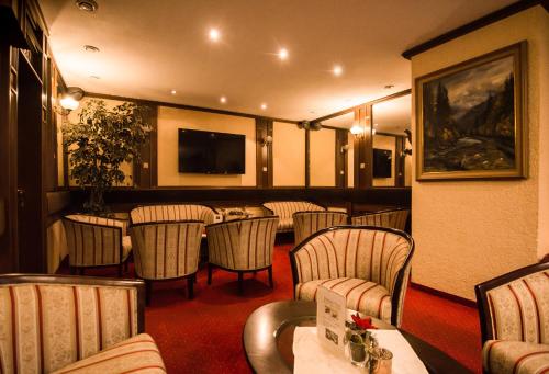 GRAND HOTEL SERGIJO RESIDENCE superior Adult only luxury boutique hotel في بييشتِني: مطعم فيه كراسي وطاولة وتلفزيون