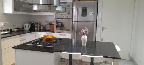 a kitchen with a black counter top with a refrigerator at LA CASITA in Buenos Aires