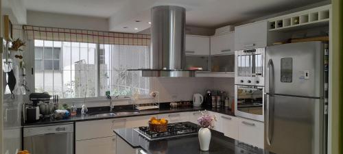 a kitchen with white cabinets and a stainless steel refrigerator at LA CASITA in Buenos Aires