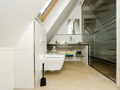a bathroom with a white toilet and a sink at de Luxe Maisonette Dünenlicht in Norderney