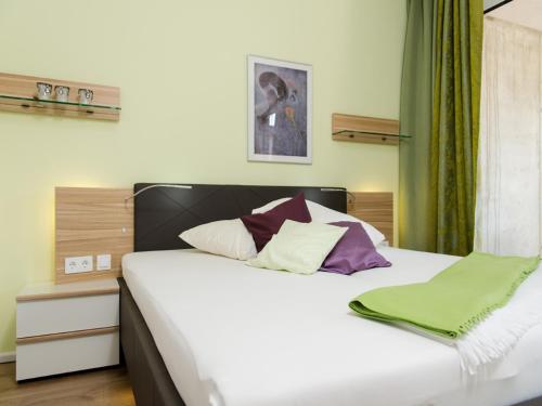 諾德奈的住宿－de Luxe Suite Sonnenaue，一间卧室配有一张带白色床单和紫色枕头的床