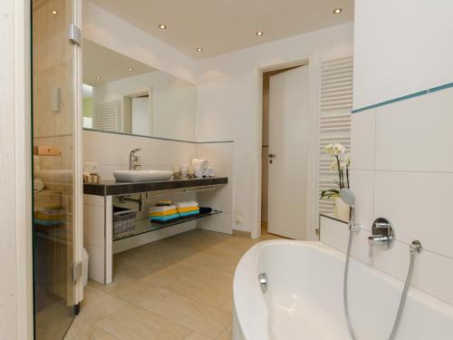 諾德奈的住宿－de Luxe Suite Sonnenaue，带浴缸和盥洗盆的浴室
