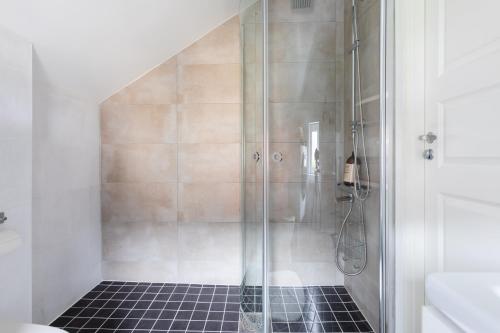 y baño con ducha y puerta de cristal. en Flores 3, en Jönköping
