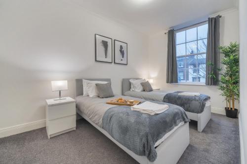 1 dormitorio con 2 camas y ventana en Modern, City Centre -2 Bedroom Apartments en Reading