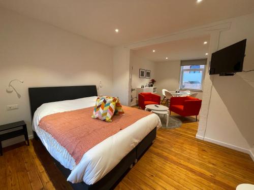 een slaapkamer met een bed en een woonkamer bij Les Gîtes Du Palais in Dinant