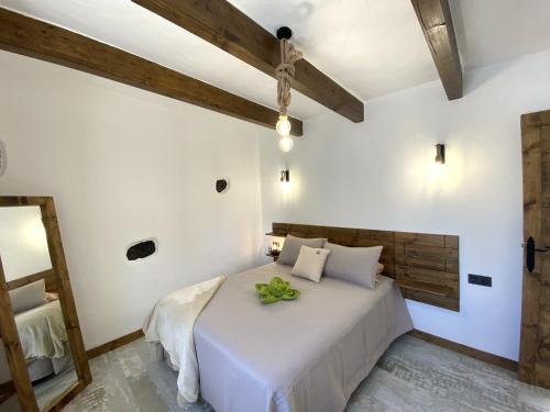 Un dormitorio con una cama blanca con una flor verde. en Ikigai, en Ye