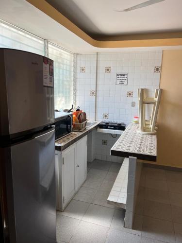 a kitchen with a stainless steel refrigerator at Hotel magallanes con cocineta 100 Metros de playa in Acapulco