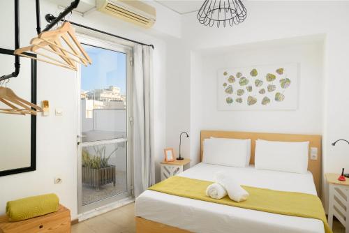 a bedroom with a bed and a large window at Crops Suites in Heraklio