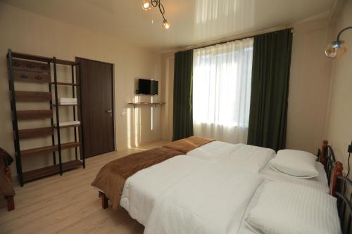 a bedroom with a large white bed and a window at CHOGO in Kutaisi