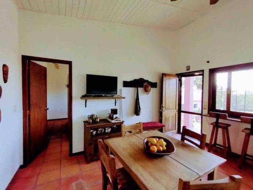 una sala de estar con una mesa de madera y un bol de fruta. en Casa de campo CLARA LUNA Sierra y Mar en Punta Ballena