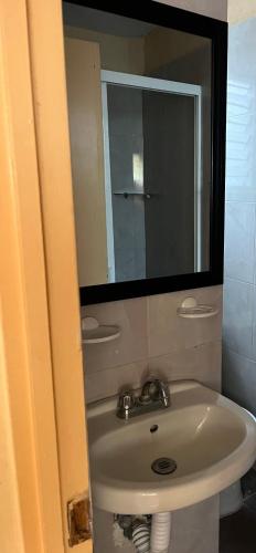 a bathroom with a sink and a mirror at Hotel magallanes con cocineta 100 Metros de playa in Acapulco