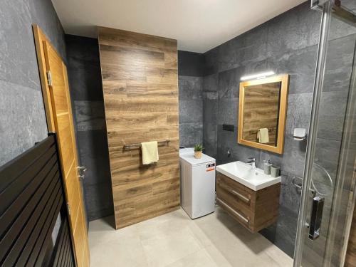 uma casa de banho com um lavatório e um espelho em New Apartment Matilda - Tatranská Lomnica em Tatranská Lomnica