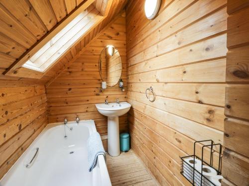 a bathroom with a tub and a sink at Moyle Lodge in Dalbeattie