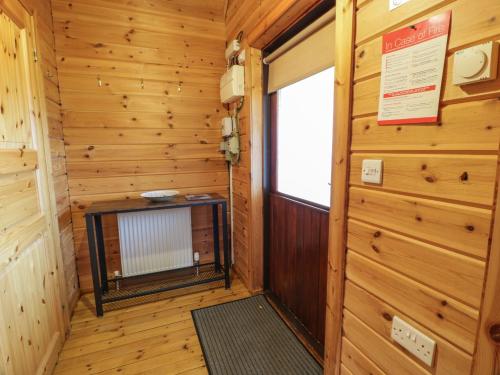 a wooden room with a door and a window at Moyle Lodge in Dalbeattie