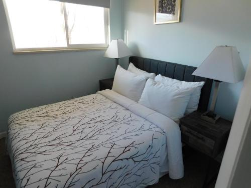 a bedroom with a bed with white sheets and a tree print at Silver Ridge Lodge in Salida