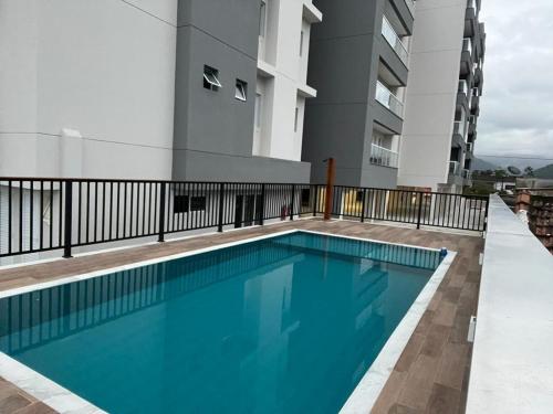 a swimming pool on the balcony of a building at Apartamento Jardins Ubatuba in Ubatuba