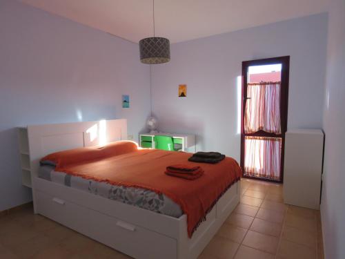 1 dormitorio con 1 cama grande con manta roja en Casa del Sol, en Corralejo