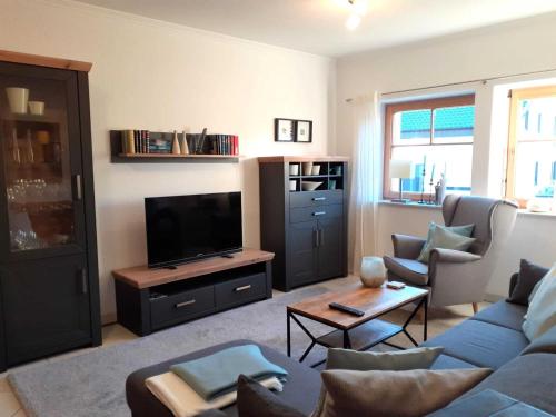 a living room with a couch and a tv at Vulkaneifel Garden Retreat in Daun
