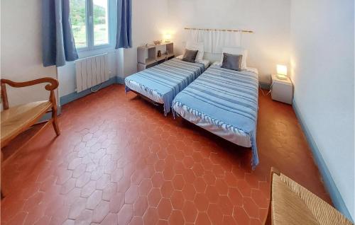 Habitación con 2 camas individuales y suelo de color rojo. en 2 Bedroom Amazing Apartment In Fox Amphoux, en Fox-Amphoux