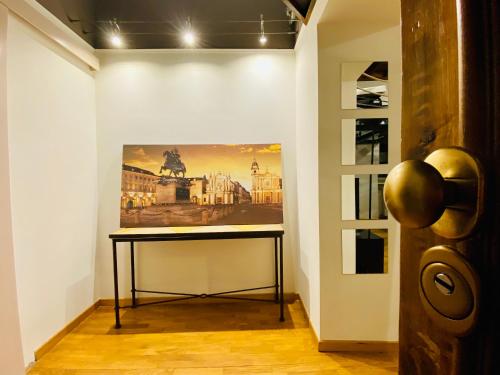 a table in a room with a painting on the wall at Cuore della città by Home a porter in Turin