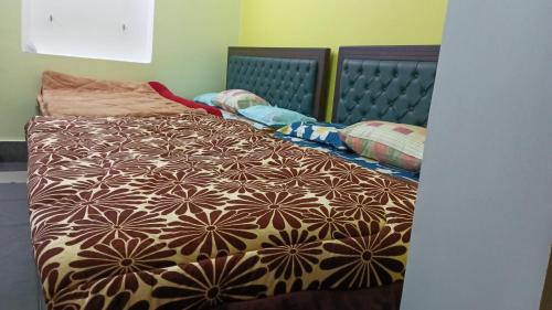 1 cama con edredón marrón y blanco en Kedar View Homestay en Ukhimath