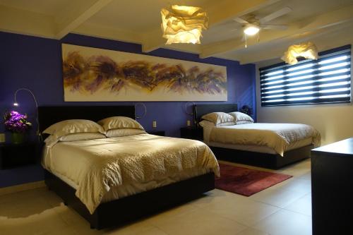 グアナファトにあるTerra Vistaのベッドルーム1室(ベッド2台付)が備わります。壁には絵画が飾られています。