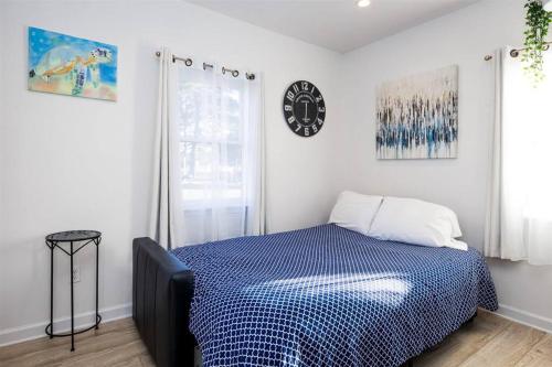 a bedroom with a bed and a clock on the wall at Experience Tiny Living, in Cape Charles, Va in Cape Charles