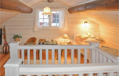 ein Zimmer mit einem Kinderbett in einem Blockhaus in der Unterkunft Lovely Home In Gunnarskog With House A Panoramic View in Gunnarskog