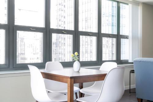 a dining room with a table and white chairs at Kasa Magnificent Mile Chicago in Chicago