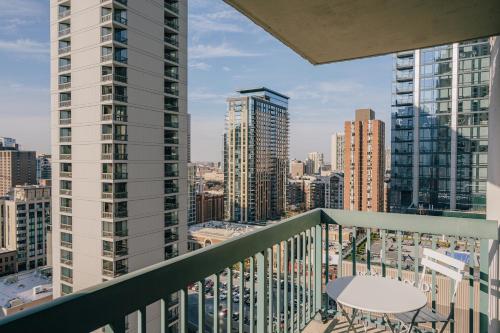 a balcony with a table and a view of a city at Kasa Magnificent Mile Chicago in Chicago