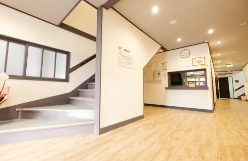 une chambre avec des escaliers et une cuisine dans un bâtiment dans l'établissement Guest House Matsuyoshi, à Lac Tōya