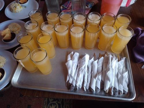 uma bandeja de comida com copos de sumo de laranja em Hotel Real del Campo em Quetzaltenango