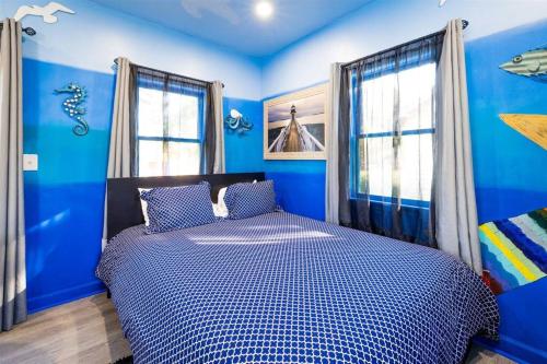 1 dormitorio azul con 1 cama con paredes y ventanas azules en Whimsical Tiny House, Cape Charles Virginia, en Cape Charles