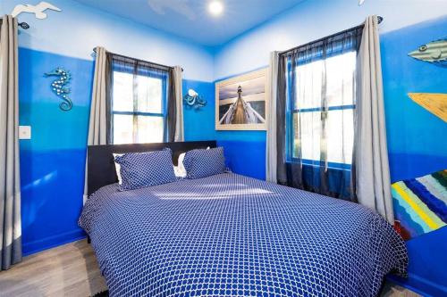 una camera blu con un letto con pareti e finestre blu di Whimsical Tiny House, Cape Charles Virginia a Cape Charles